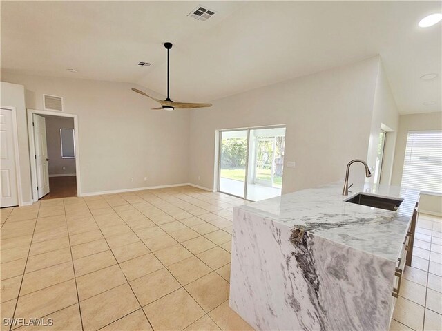 1221 SW 10th Ter, Cape Coral, FL 33991 - kitchen featuring light tile patterned floors, lofted ceiling, a sink, ceiling fan, and light stone counters