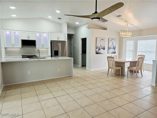 1221 SW 10th Ter, Cape Coral, FL 33991 - kitchen featuring stainless steel appliances, vaulted ceiling, a sink, light countertops, and white cabinetry