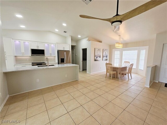 1221 SW 10th Ter, Cape Coral, FL 33991 - kitchen featuring appliances with stainless steel finishes, light countertops, white cabinets, vaulted ceiling, and light tile patterned flooring