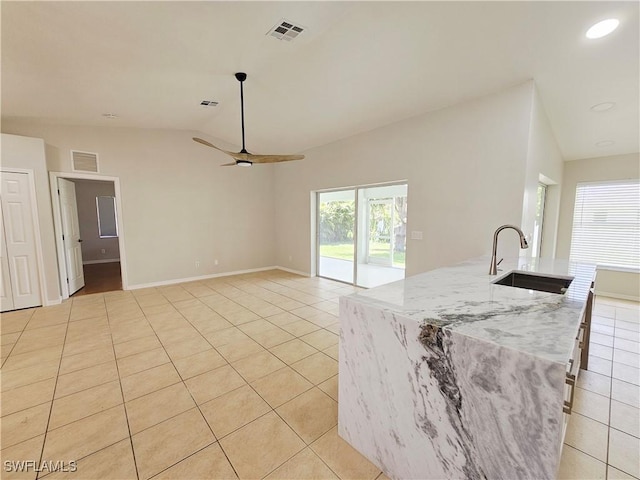 1221 SW 10th Ter, Cape Coral, FL 33991 - kitchen with a sink, light tile patterned floors, lofted ceiling, a ceiling fan, and light stone countertops