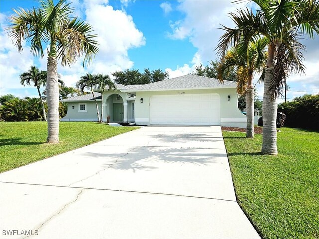 1221 SW 10th Ter, Cape Coral, FL 33991 - ranch-style home with stucco siding, driveway, a garage, and a front yard