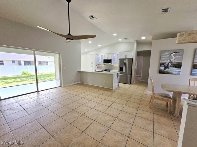 1221 SW 10th Ter, Cape Coral, FL 33991 - kitchen featuring stainless steel appliances, lofted ceiling, a sink, light tile patterned floors, and white cabinetry