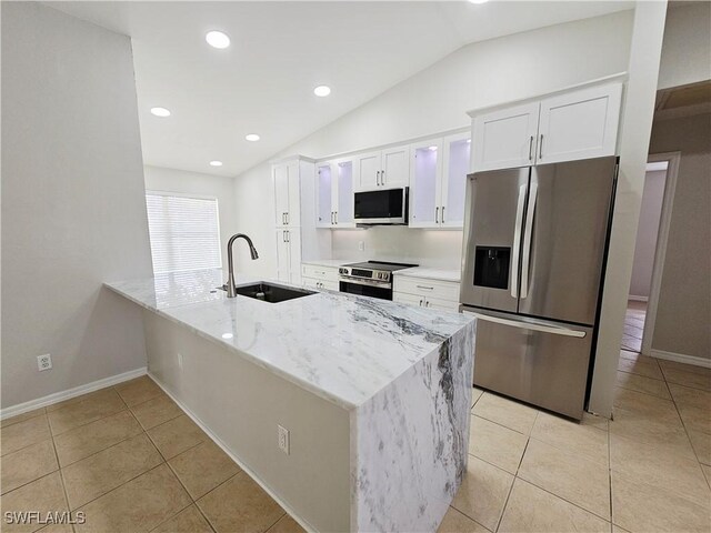 1221 SW 10th Ter, Cape Coral, FL 33991 - kitchen featuring appliances with stainless steel finishes, a sink, vaulted ceiling, white cabinets, and light tile patterned floors