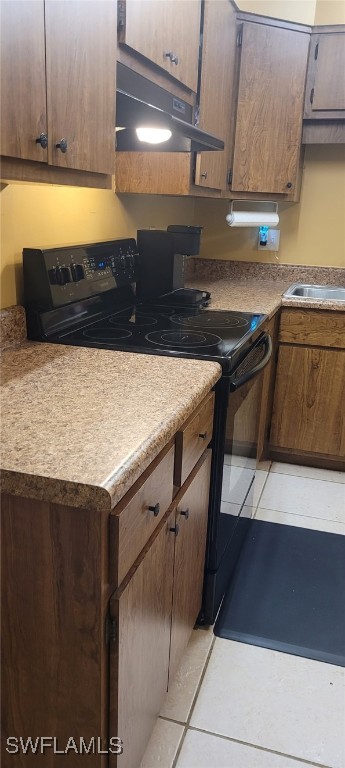 2325 55th Ter SW, Naples, FL 34116 - kitchen featuring light tile patterned floors, under cabinet range hood, black range with electric cooktop, and light countertops