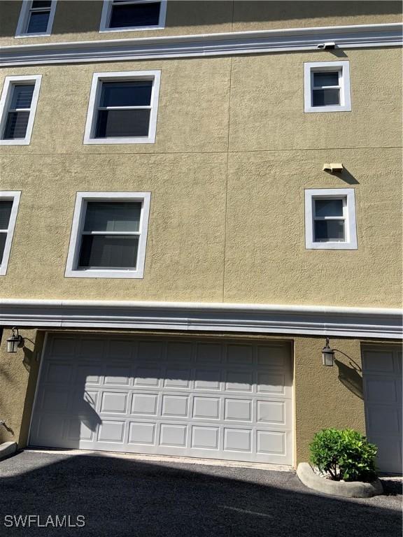 10041 Lake Cove Dr Unit 202, Fort Myers, FL 33908 - view of home's exterior with stucco siding and a garage