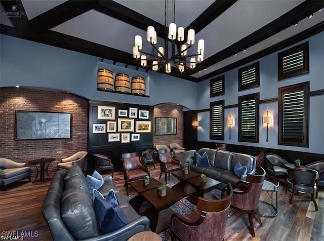 19477 The Place Blvd, Estero, FL 33928 - cinema room with wood finished floors, a chandelier, beamed ceiling, a towering ceiling, and brick wall