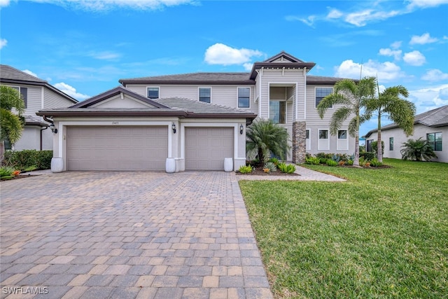 19477 The Place Blvd, Estero, FL 33928 - view of front facade featuring decorative driveway, a front yard, a garage, and stucco siding