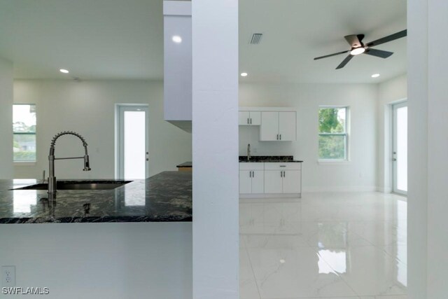 2501 26th St W, Lehigh Acres, FL 33971 - kitchen featuring recessed lighting, dark stone countertops, light marble finish flooring, white cabinets, and a ceiling fan