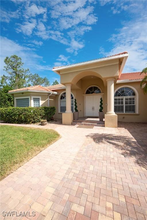 1640 Golden Gate Blvd W, Naples, FL 34117 - view of front of property featuring a tiled roof, stucco siding, and a front yard