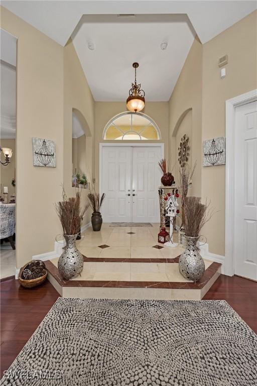 1640 Golden Gate Blvd W, Naples, FL 34117 - entryway with a chandelier, wood finished floors, and lofted ceiling