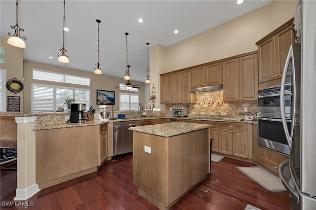 1640 Golden Gate Blvd W, Naples, FL 34117 - kitchen with appliances with stainless steel finishes, a peninsula, a kitchen island, backsplash, and dark wood-style floors