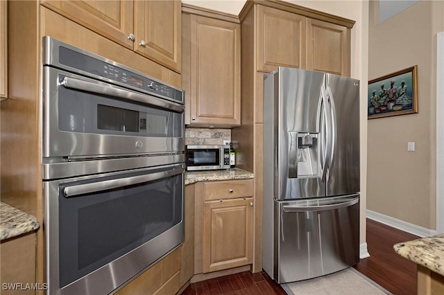 1640 Golden Gate Blvd W, Naples, FL 34117 - kitchen with stainless steel appliances, dark wood finished floors, light stone counters, and backsplash