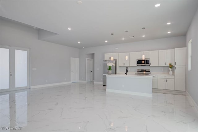 3121 71st St W, Lehigh Acres, FL 33971 - kitchen with stainless steel appliances, baseboards, recessed lighting, a center island with sink, and white cabinets