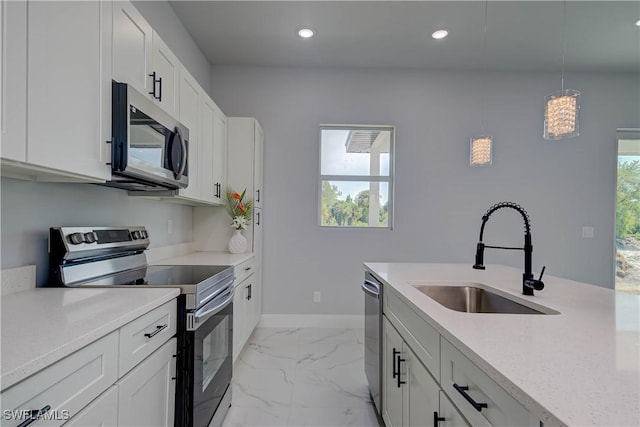 3417 71st St W, Lehigh Acres, FL 33971 - kitchen with appliances with stainless steel finishes, a sink, light marble finish flooring, baseboards, and pendant lighting