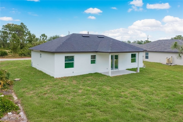 3417 71st St W, Lehigh Acres, FL 33971 - back of property with a shingled roof, a patio area, a lawn, and stucco siding