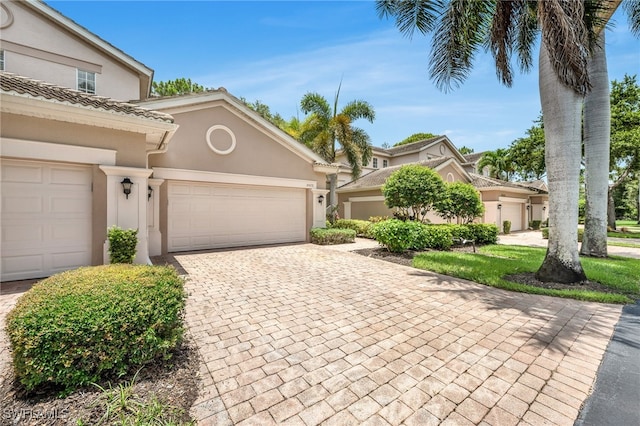 28220 Caballero Way Unit 2422, Bonita Springs, FL 34135 - view of front facade featuring stucco siding, decorative driveway, and an attached garage