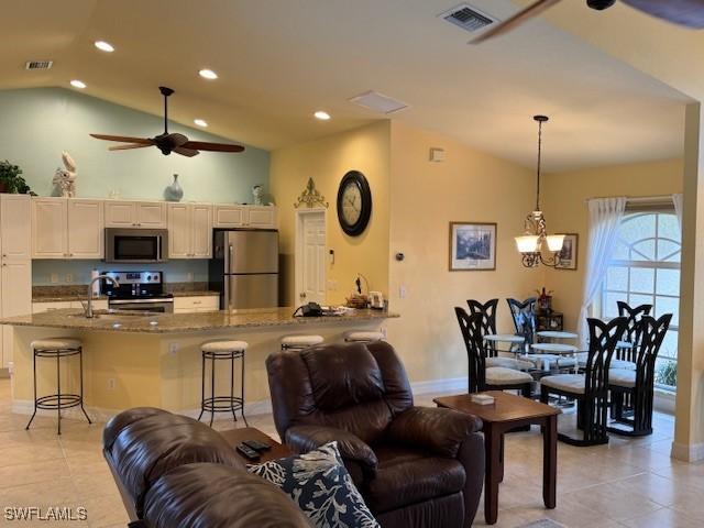 1505 NW 33rd Pl, Cape Coral, FL 33993 - living room featuring lofted ceiling, light tile patterned flooring, recessed lighting, a ceiling fan, and a chandelier