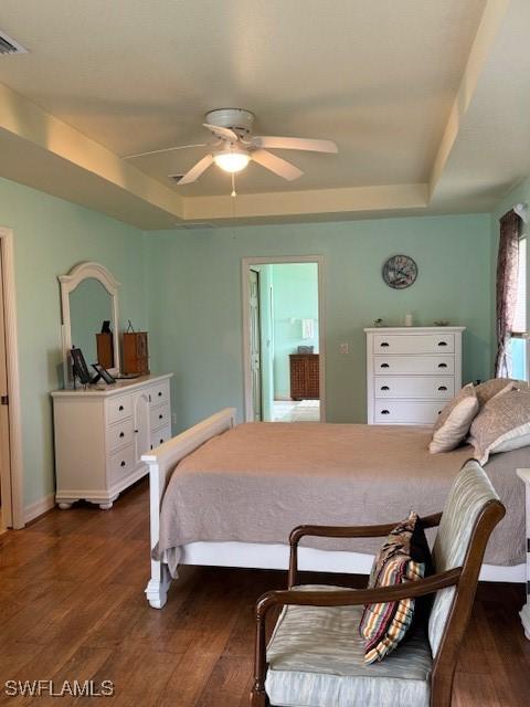 1505 NW 33rd Pl, Cape Coral, FL 33993 - bedroom featuring a raised ceiling, dark wood-style flooring, and ceiling fan