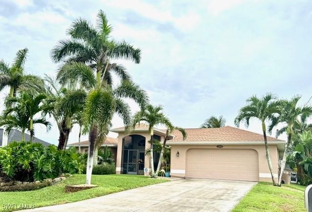 1505 NW 33rd Pl, Cape Coral, FL 33993 - view of front of property with stucco siding, an attached garage, concrete driveway, and a front lawn