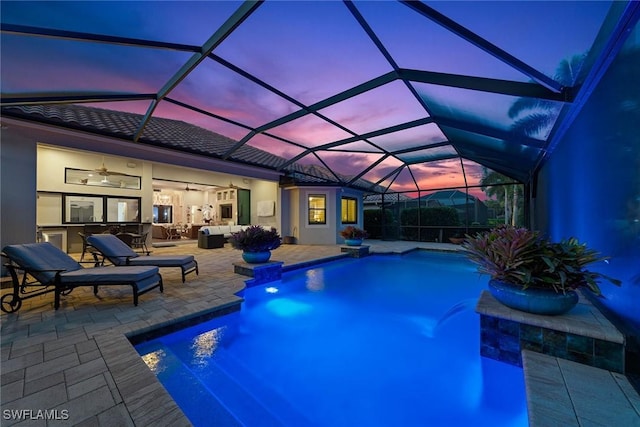 11950 Heather Woods Ct, Naples, FL 34120 - pool at dusk with a ceiling fan, an outdoor pool, an outdoor living space, and a patio area