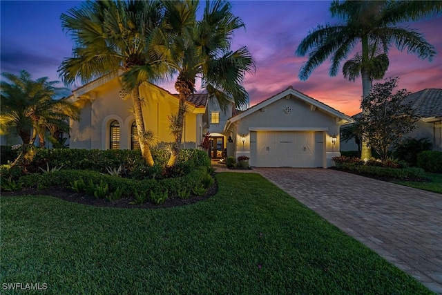 11950 Heather Woods Ct, Naples, FL 34120 - mediterranean / spanish-style house with stucco siding, decorative driveway, a lawn, and an attached garage