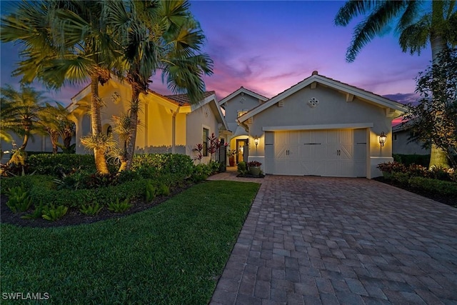 11950 Heather Woods Ct, Naples, FL 34120 - view of front of home with decorative driveway, stucco siding, a garage, and a front lawn