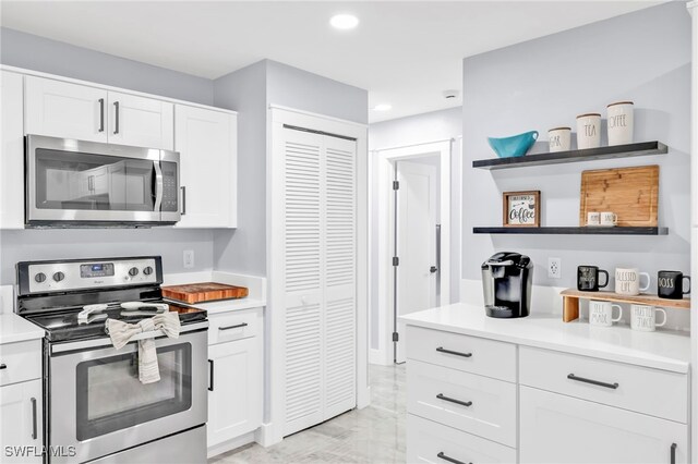 628 SW 9th Ave, Cape Coral, FL 33991 - kitchen with appliances with stainless steel finishes, open shelves, white cabinets, light countertops, and recessed lighting