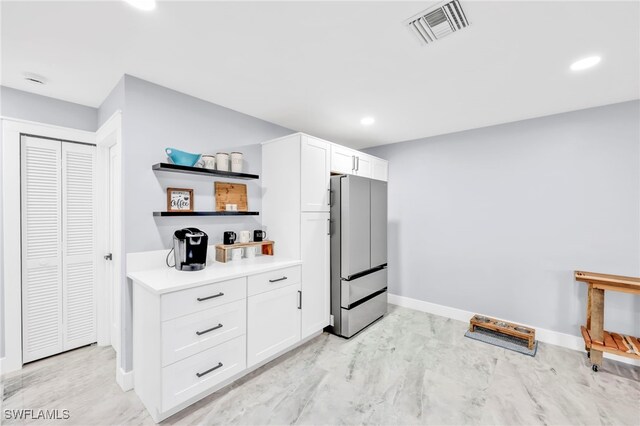 628 SW 9th Ave, Cape Coral, FL 33991 - kitchen with freestanding refrigerator, open shelves, white cabinets, baseboards, and light countertops