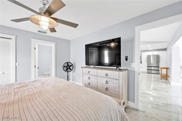 628 SW 9th Ave, Cape Coral, FL 33991 - bedroom featuring freestanding refrigerator, light marble finish floors, baseboards, ceiling fan, and ensuite bath