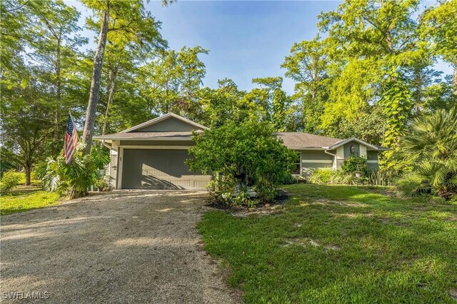 1440 14th Ave NE, Naples, FL 34120 - view of front facade with dirt driveway, a garage, and a front lawn