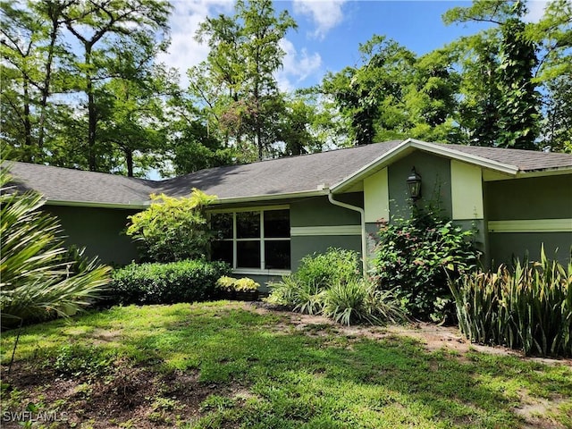 1440 14th Ave NE, Naples, FL 34120 - view of home's exterior featuring stucco siding and a yard