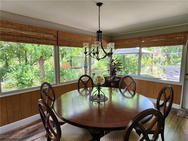 1440 14th Ave NE, Naples, FL 34120 - dining space featuring healthy amount of natural light, wood finished floors, a chandelier, and wooden walls