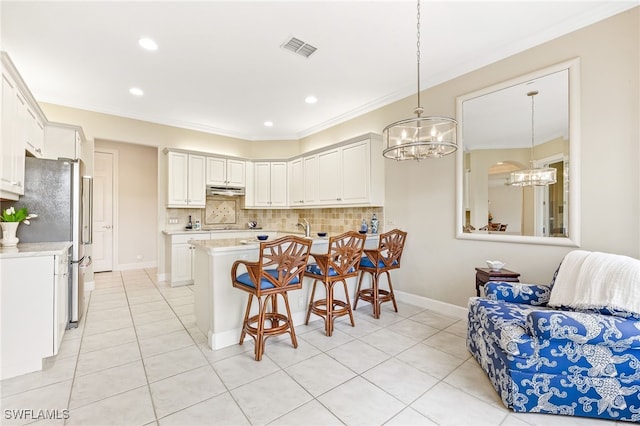 3051 Lancaster Dr Unit 4, Naples, FL 34105 - kitchen featuring a chandelier, freestanding refrigerator, a kitchen breakfast bar, light countertops, and light tile patterned floors