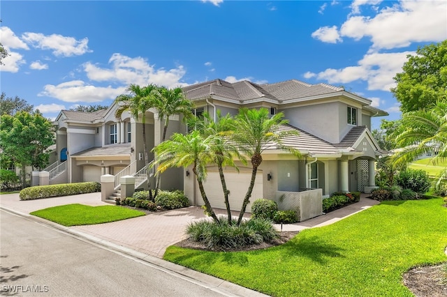 3051 Lancaster Dr Unit 4, Naples, FL 34105 - view of front of home with decorative driveway, stucco siding, a front lawn, and a tiled roof
