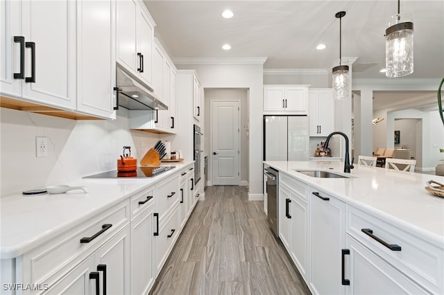 kitchen with freestanding refrigerator, under cabinet range hood, crown molding, white cabinets, and recessed lighting
