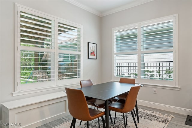 dining space with healthy amount of natural light, light wood-style floors, and ornamental molding