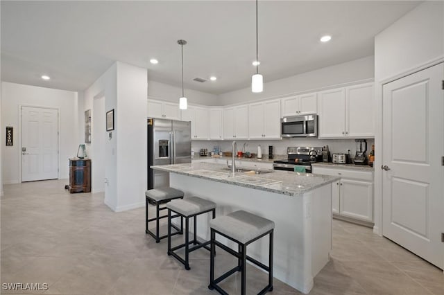 14688 Cantabria Dr, Fort Myers, FL 33905 - kitchen with stainless steel appliances, a breakfast bar, white cabinetry, recessed lighting, and a kitchen island with sink