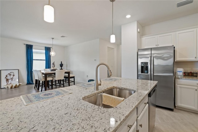 14688 Cantabria Dr, Fort Myers, FL 33905 - kitchen featuring appliances with stainless steel finishes, white cabinetry, decorative light fixtures, light stone countertops, and recessed lighting
