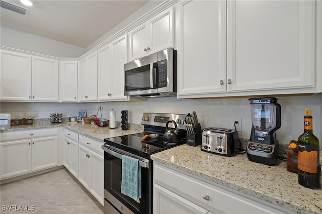 14688 Cantabria Dr, Fort Myers, FL 33905 - kitchen featuring stainless steel appliances, white cabinets, light stone countertops, and light tile patterned flooring
