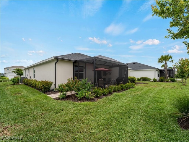 17857 Woodland Ct, Punta Gorda, FL 33982 - back of house featuring a lawn, stucco siding, and glass enclosure