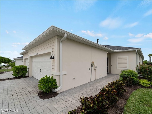 17857 Woodland Ct, Punta Gorda, FL 33982 - view of property exterior with stucco siding, an attached garage, and driveway