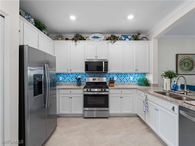 17857 Woodland Ct, Punta Gorda, FL 33982 - kitchen with stainless steel appliances, ornamental molding, white cabinetry, and decorative backsplash