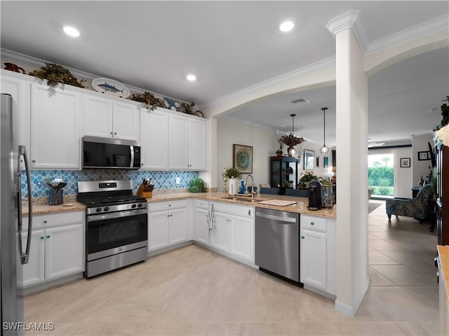 17857 Woodland Ct, Punta Gorda, FL 33982 - kitchen with stainless steel appliances, crown molding, tasteful backsplash, arched walkways, and light stone counters