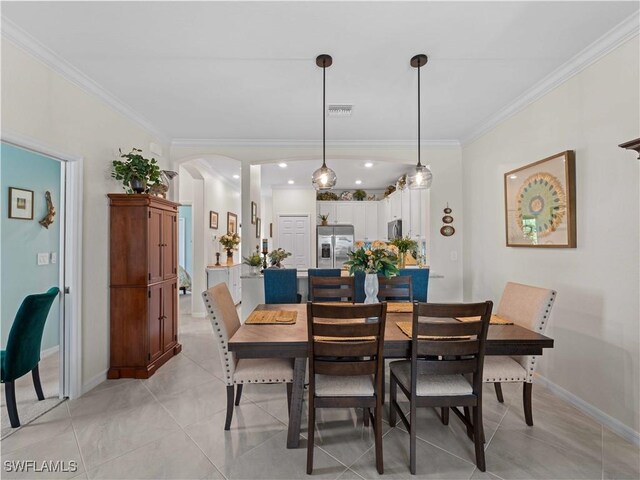 17857 Woodland Ct, Punta Gorda, FL 33982 - dining area featuring arched walkways, crown molding, and light tile patterned floors