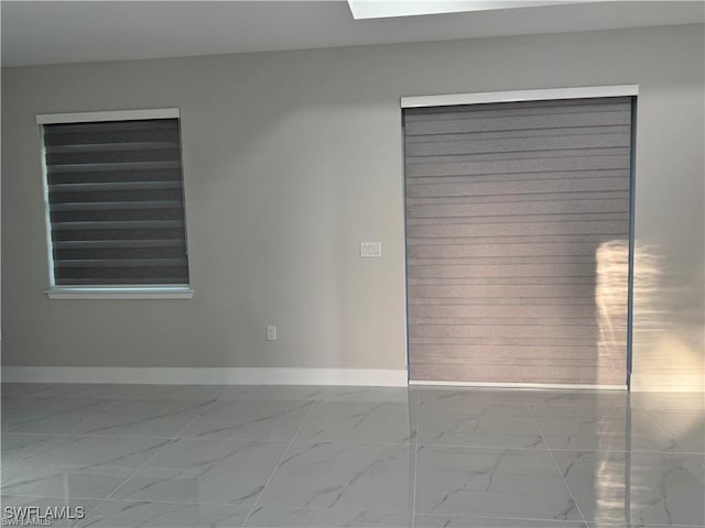 3003 18th St W, Lehigh Acres, FL 33976 - spare room with marble look tile flooring and baseboards