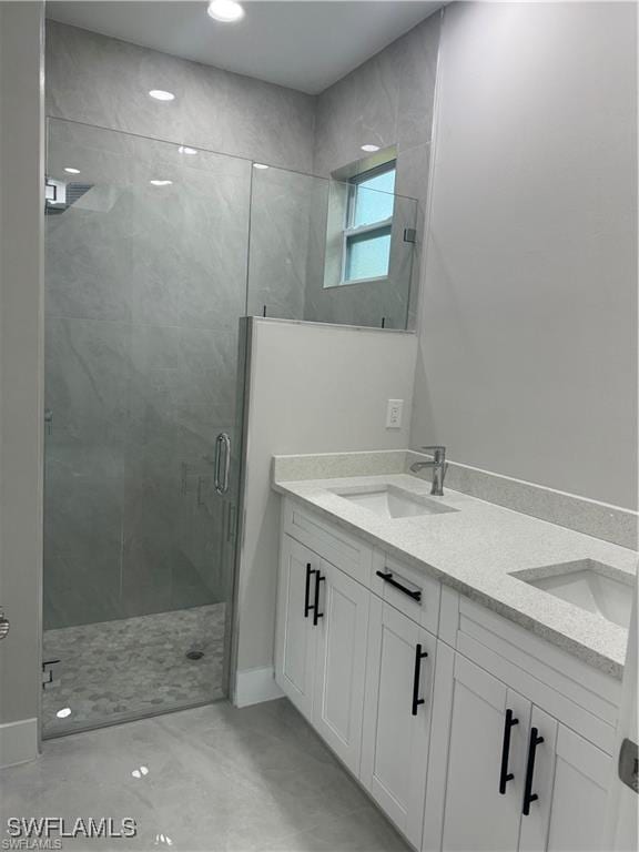 3003 18th St W, Lehigh Acres, FL 33976 - bathroom with a shower stall, double vanity, and baseboards
