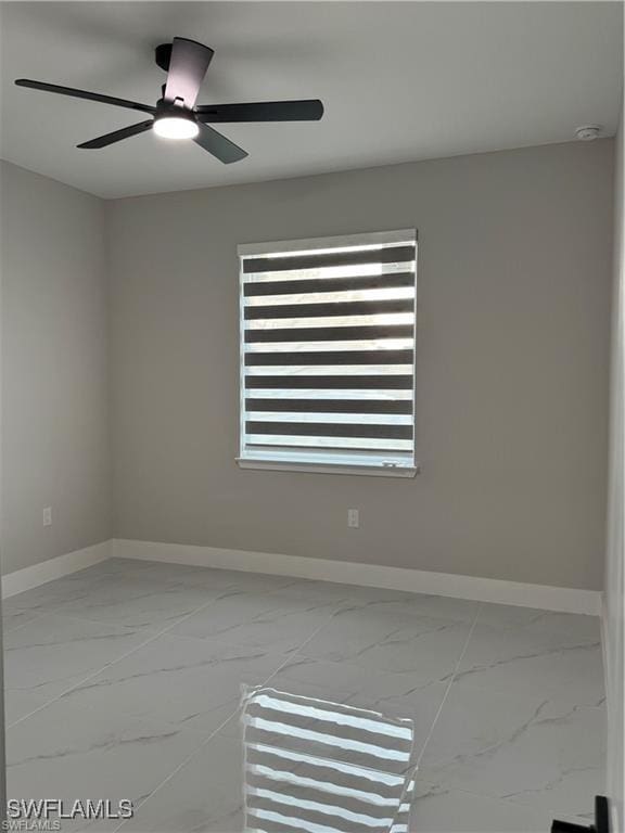 3003 18th St W, Lehigh Acres, FL 33976 - unfurnished room with marble look tiles, baseboards, and ceiling fan