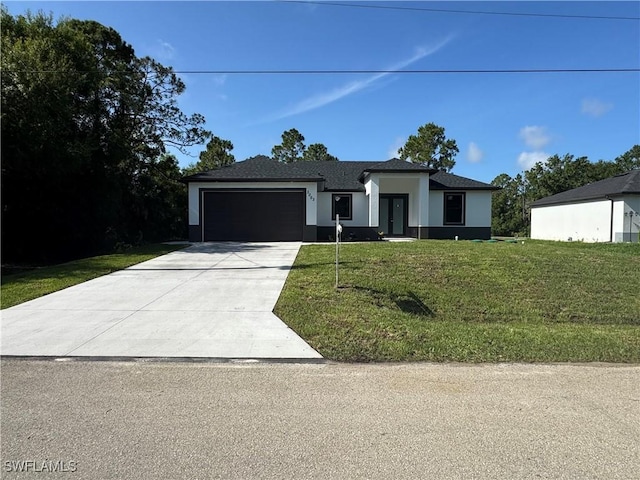 3003 18th St W, Lehigh Acres, FL 33976 - prairie-style house with a garage, concrete driveway, stucco siding, and a front yard