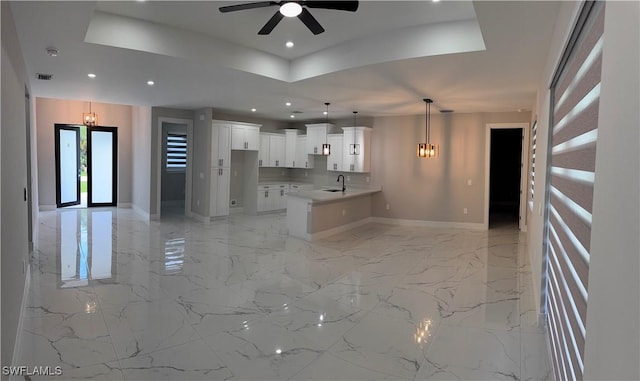 3003 18th St W, Lehigh Acres, FL 33976 - unfurnished living room with a tray ceiling, a ceiling fan, recessed lighting, light marble finish flooring, and a chandelier