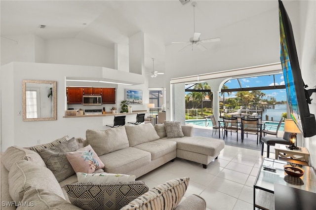 3925 Oasis Blvd, Cape Coral, FL 33914 - living area featuring high vaulted ceiling, ceiling fan, light tile patterned floors, and a water view